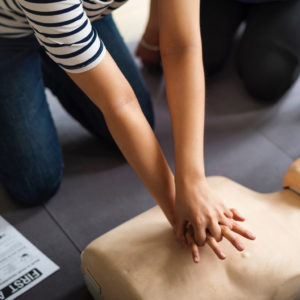 someone doing CPR on a manikin